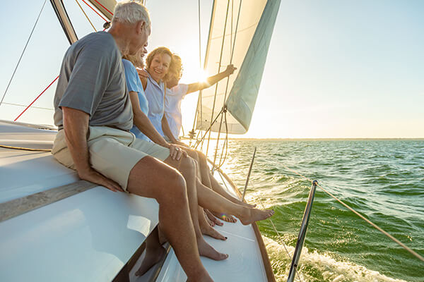 Ältere Menschen genießen den Sonnenuntergang auf einem Segelboot